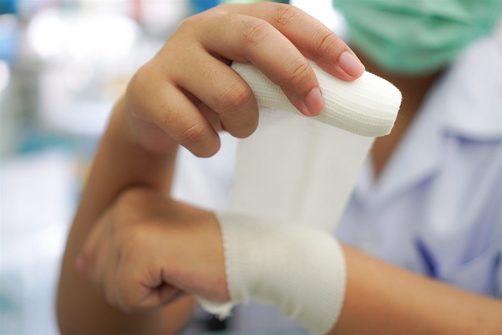 A nurse changing a wound dressing on a patient's hand
