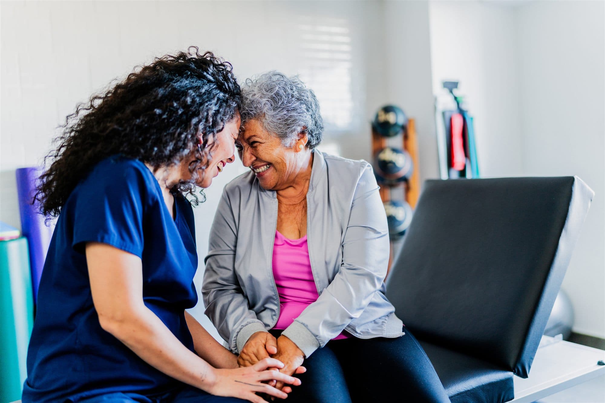 A caregiver and an older adult sharing a warm, caring moment at home