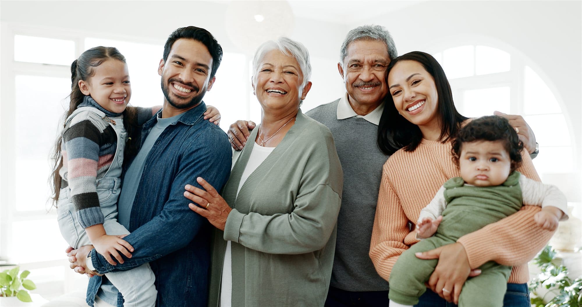 Three generations of a family smiling together at home